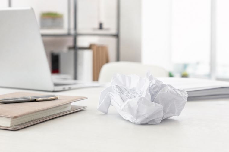 Una donna seduta tiene tra le mani un foglio stampato e lo rilegge con attenzione